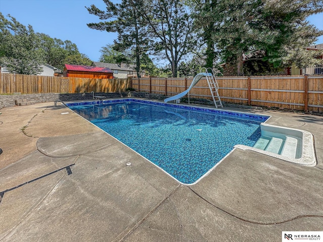 7533 Sherman St, Lincoln, NE 68506 - view of swimming pool featuring a water slide, a fenced backyard, and a patio