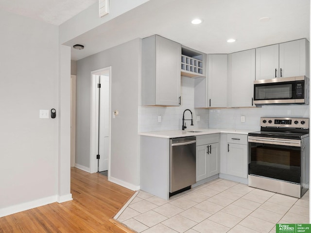 5075 Frances St, Omaha, NE 68106 - kitchen with stainless steel appliances, open shelves, light countertops, tasteful backsplash, and light wood finished floors