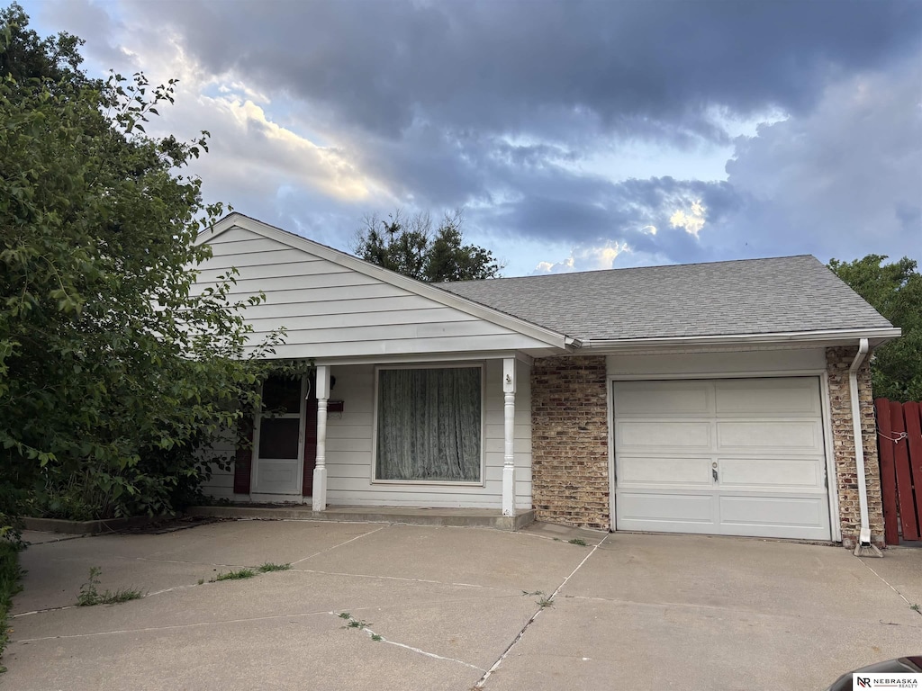 3108 S 134th St, Omaha, NE 68144 - view of front of property with concrete driveway, an attached garage, brick siding, and a shingled roof