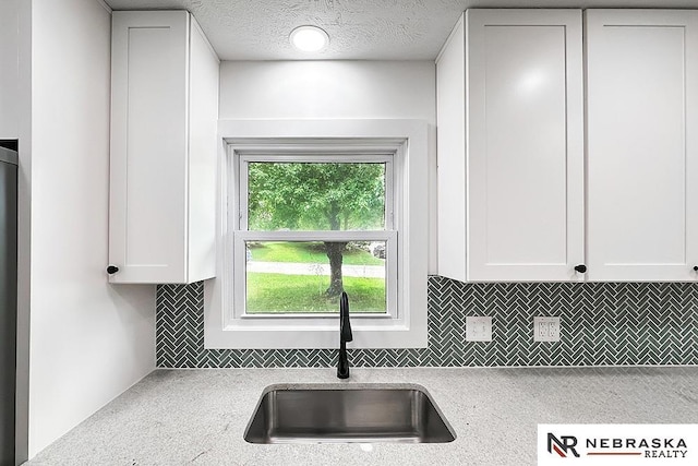 1113 S 94th St, Omaha, NE 68124 - kitchen with tasteful backsplash, white cabinetry, light countertops, and a textured ceiling