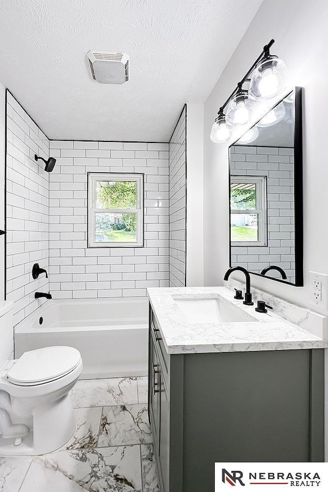 1113 S 94th St, Omaha, NE 68124 - bathroom with vanity, marble look tiles, a textured ceiling, and shower / tub combination