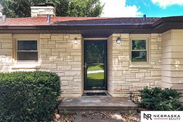 1113 S 94th St, Omaha, NE 68124 - doorway to property with stone siding, a chimney, and a shingled roof
