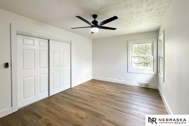 1113 S 94th St, Omaha, NE 68124 - unfurnished bedroom with wood finished floors, a closet, and a ceiling fan