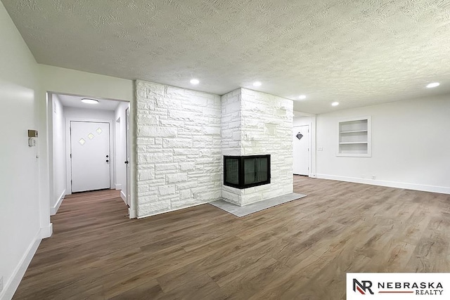 1113 S 94th St, Omaha, NE 68124 - unfurnished living room featuring a textured ceiling, wood finished floors, a fireplace, recessed lighting, and built in features