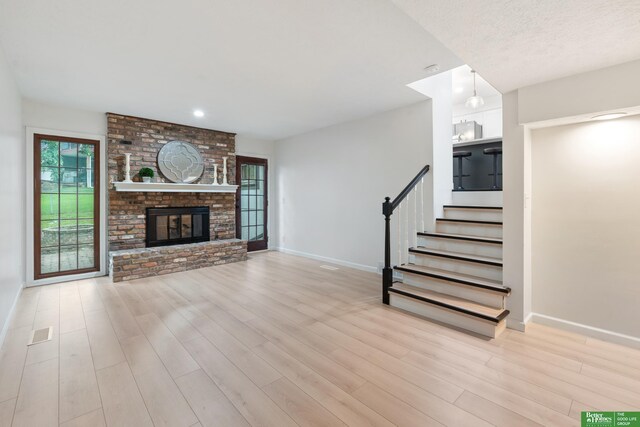203 S 150th Cir, Omaha, NE 68154 - unfurnished living room with wood finished floors, stairway, a brick fireplace, and recessed lighting