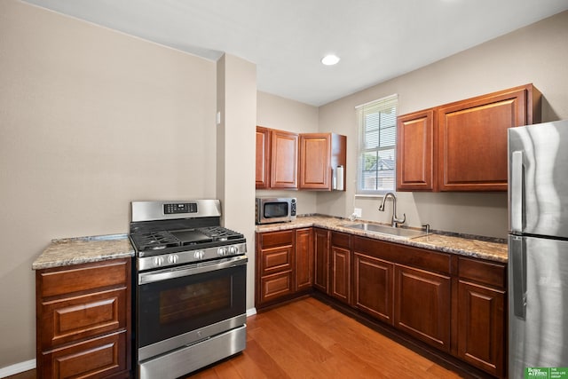 4516 S 33rd St, Omaha, NE 68107 - kitchen with appliances with stainless steel finishes, light wood finished floors, light stone counters, and recessed lighting