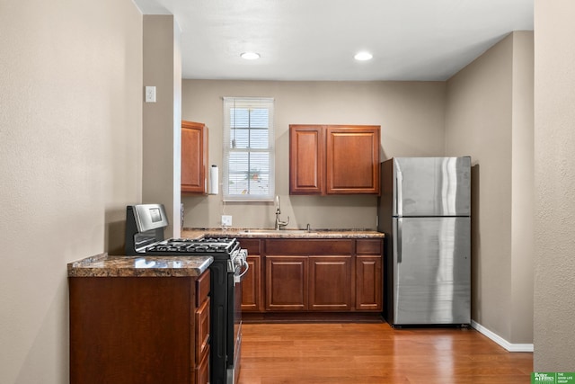 4516 S 33rd St, Omaha, NE 68107 - kitchen featuring stainless steel appliances, light wood-style flooring, dark stone counters, and recessed lighting