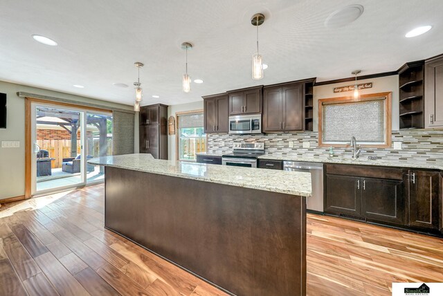 4721 Woodhaven Dr, Lincoln, NE 68516 - kitchen featuring open shelves, stainless steel appliances, dark brown cabinetry, a kitchen island, and tasteful backsplash