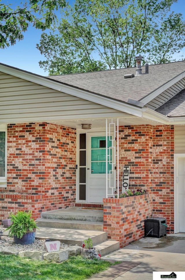 4721 Woodhaven Dr, Lincoln, NE 68516 - entrance to property featuring roof with shingles, brick siding, and a porch
