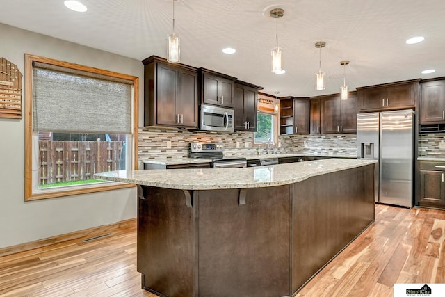 4721 Woodhaven Dr, Lincoln, NE 68516 - kitchen featuring appliances with stainless steel finishes, dark brown cabinetry, light wood finished floors, tasteful backsplash, and recessed lighting