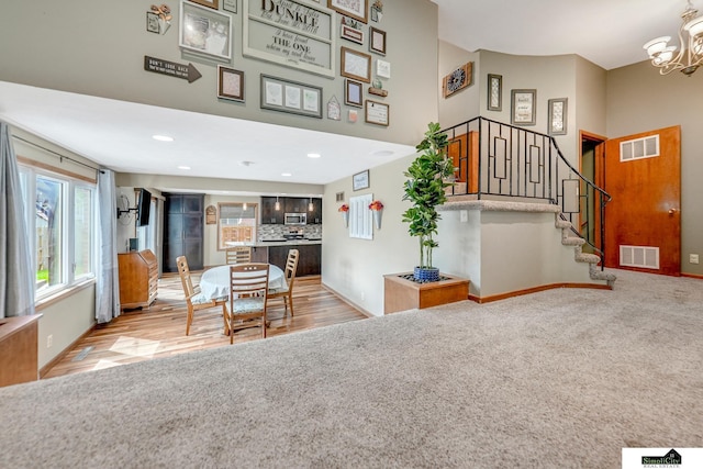 4721 Woodhaven Dr, Lincoln, NE 68516 - dining room featuring stairs, a chandelier, a high ceiling, recessed lighting, and wood finished floors