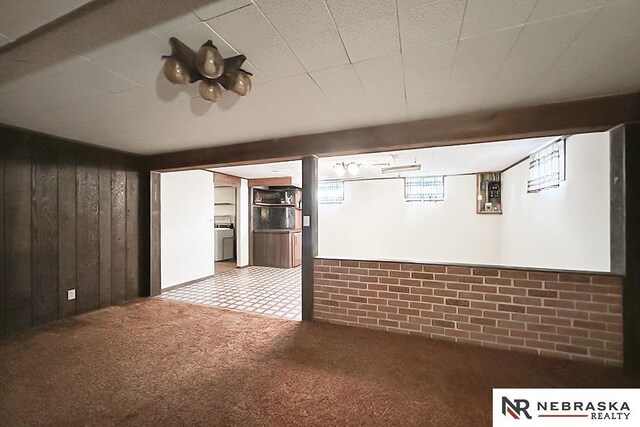 4520 Polk St, Omaha, NE 68117 - unfurnished living room featuring wooden walls, carpet flooring, and washer / dryer
