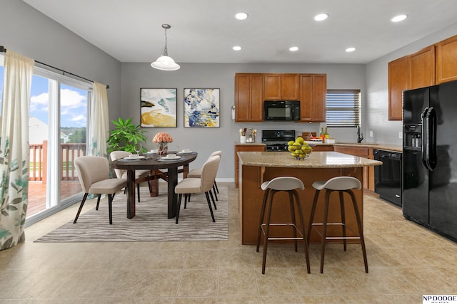 20709 Larimore Ave, Elkhorn, NE 68022 - kitchen with black appliances, a center island, a kitchen breakfast bar, brown cabinets, and recessed lighting