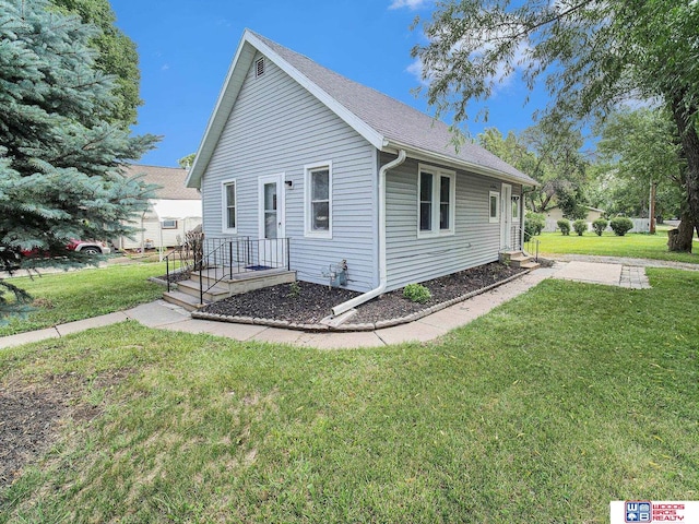 4308 N 70th St, Lincoln, NE 68507 - view of side of home featuring a yard and a shingled roof