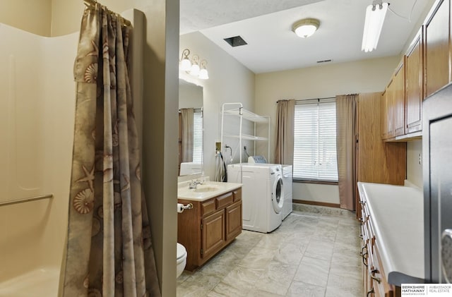 2618 Platte River Dr, Bellevue, NE 68123 - bathroom featuring washing machine and dryer, vanity, marble finish flooring, and a shower with curtain