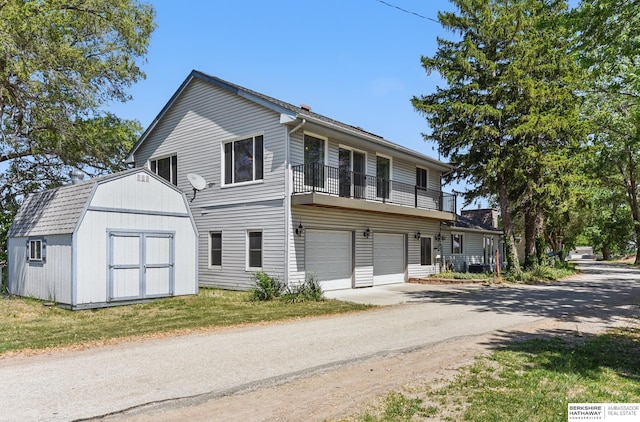 2618 Platte River Dr, Bellevue, NE 68123 - view of front facade featuring driveway, a garage, a balcony, and a storage unit