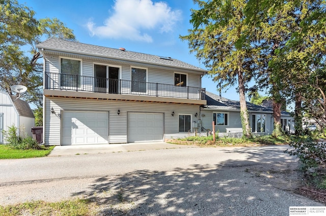2618 Platte River Dr, Bellevue, NE 68123 - view of front facade with a garage, a balcony, driveway, and roof with shingles