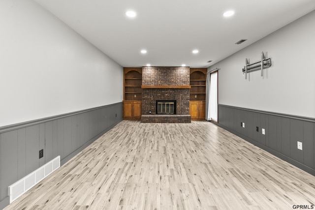 3728 Schuemann Dr, Bellevue, NE 68123 - unfurnished living room with wood finished floors, wainscoting, recessed lighting, a brick fireplace, and built in features