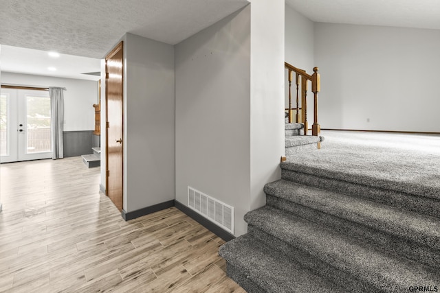 3728 Schuemann Dr, Bellevue, NE 68123 - staircase featuring wood finished floors, french doors, and a textured ceiling
