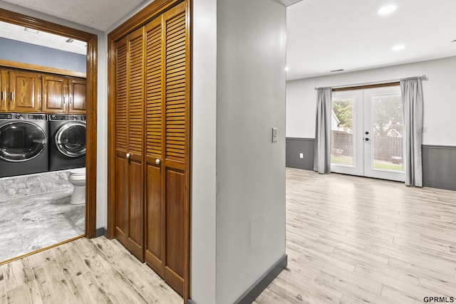 3728 Schuemann Dr, Bellevue, NE 68123 - laundry room featuring washing machine and clothes dryer, light wood finished floors, a wainscoted wall, french doors, and cabinet space