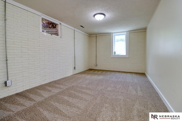 506 Rockhurst Dr, Lincoln, NE 68510 - carpeted empty room featuring brick wall and a textured ceiling