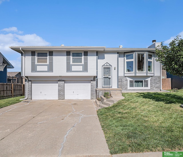 8006 S 154th St, Omaha, NE 68138 - bi-level home with a garage, concrete driveway, and a chimney