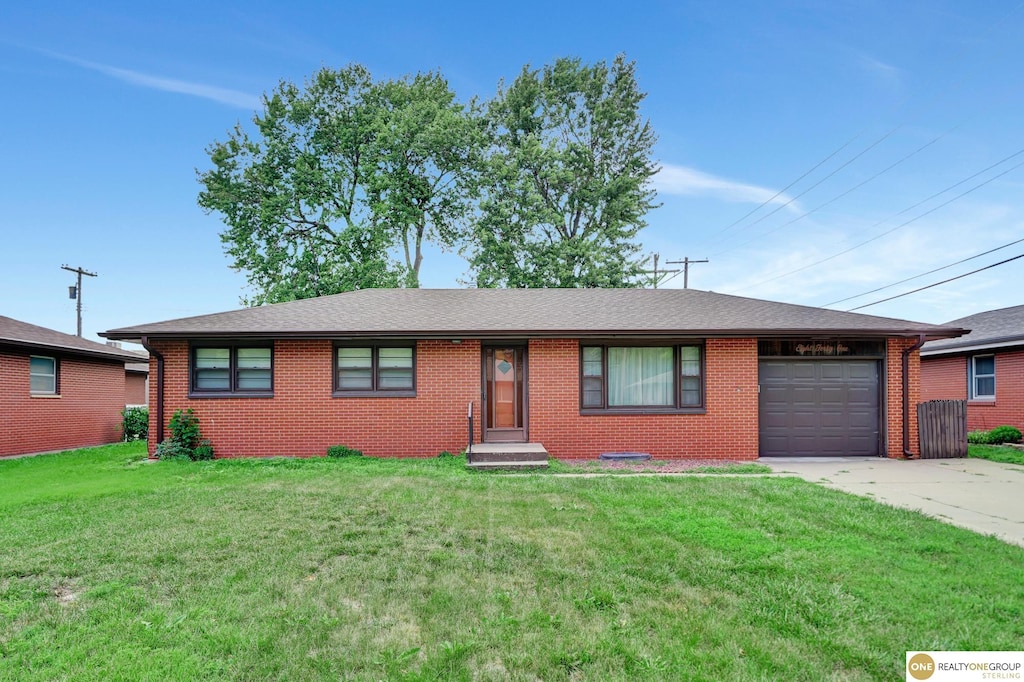 841 Hollywood Ave, Lincoln, NE 68504 - ranch-style house with an attached garage, driveway, a front yard, and brick siding