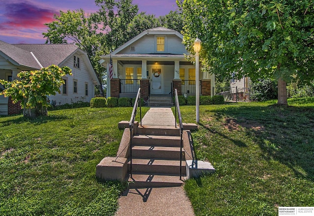 1422 S 52nd St, Omaha, NE 68106 - view of front facade featuring a porch, a front yard, and brick siding