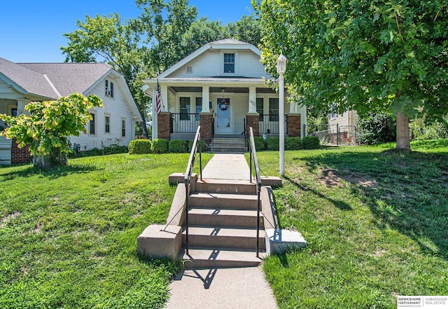 1422 S 52nd St, Omaha, NE 68106 - view of front of house featuring covered porch, a front yard, and brick siding