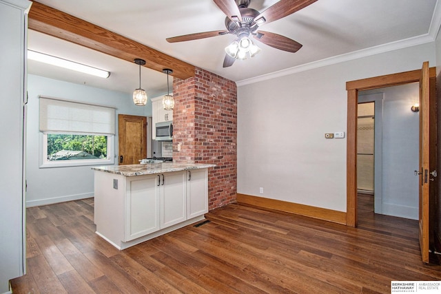1422 S 52nd St, Omaha, NE 68106 - kitchen with stainless steel microwave, a peninsula, white cabinets, dark wood-type flooring, and light stone countertops