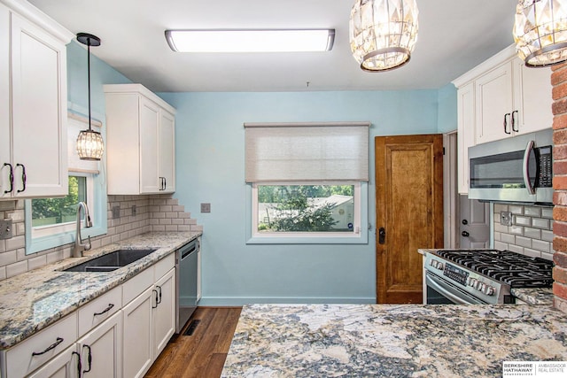 1422 S 52nd St, Omaha, NE 68106 - kitchen featuring appliances with stainless steel finishes, light stone counters, backsplash, and white cabinetry