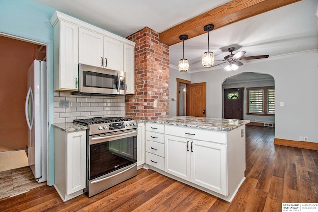 1422 S 52nd St, Omaha, NE 68106 - kitchen with appliances with stainless steel finishes, a peninsula, white cabinetry, a ceiling fan, and arched walkways
