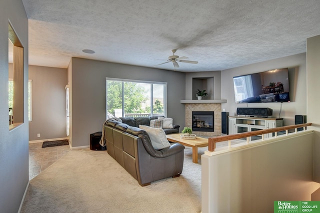 1608 Old Gaelic St, Bellevue, NE 68123 - living room with a ceiling fan, a tiled fireplace, carpet, and a textured ceiling