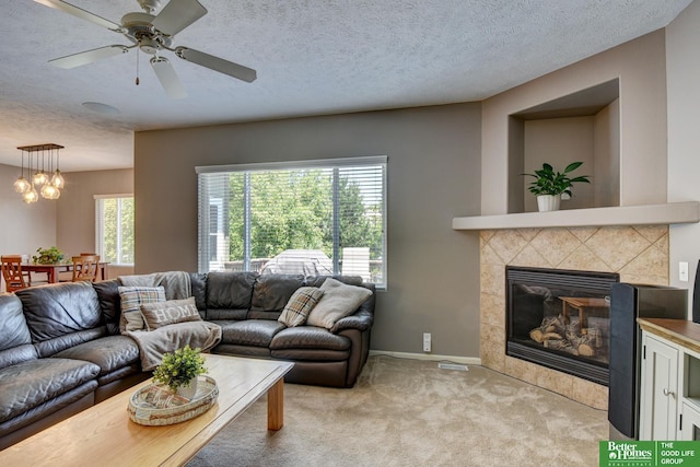 1608 Old Gaelic St, Bellevue, NE 68123 - living room with light carpet, a chandelier, a textured ceiling, a ceiling fan, and a tile fireplace