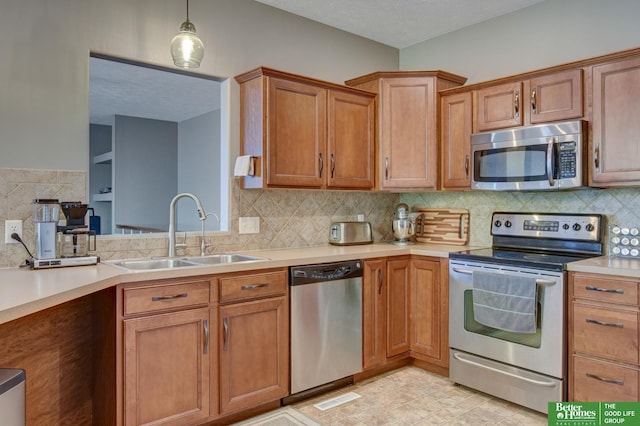 1608 Old Gaelic St, Bellevue, NE 68123 - kitchen with appliances with stainless steel finishes, light countertops, brown cabinetry, and pendant lighting