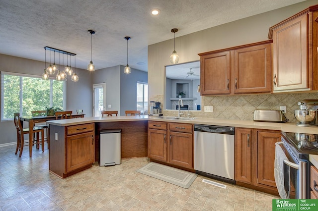 1608 Old Gaelic St, Bellevue, NE 68123 - kitchen with appliances with stainless steel finishes, brown cabinets, light countertops, decorative backsplash, and a textured ceiling