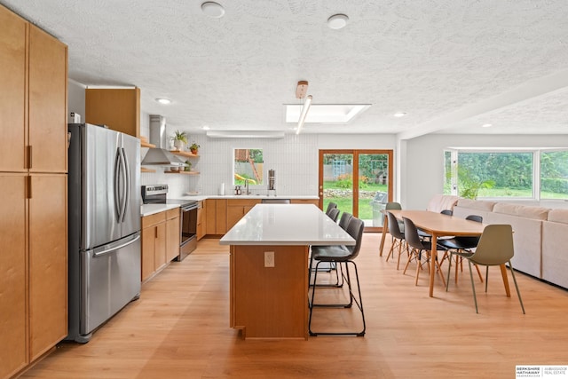 1133 S 96th St, Omaha, NE 68124 - kitchen with stainless steel appliances, wall chimney exhaust hood, a breakfast bar, a textured ceiling, and a center island
