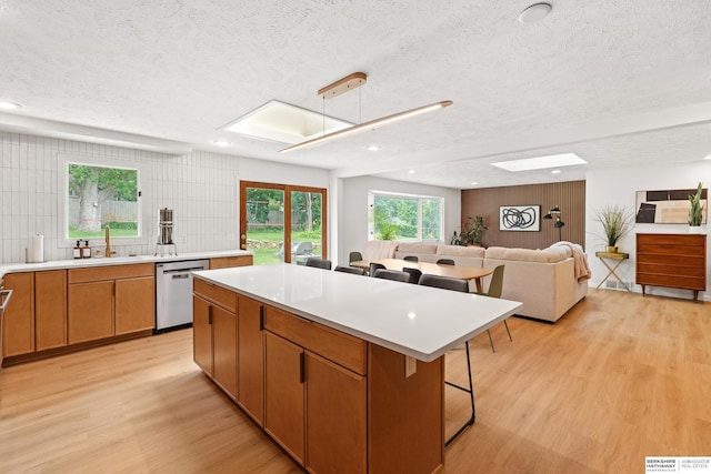 1133 S 96th St, Omaha, NE 68124 - kitchen with dishwasher, a textured ceiling, light wood finished floors, a kitchen bar, and a center island