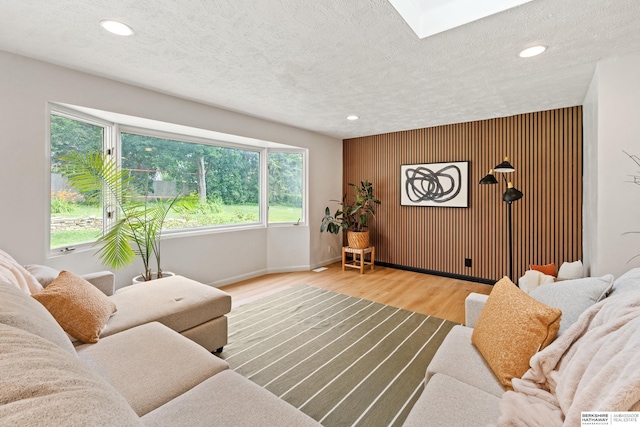 1133 S 96th St, Omaha, NE 68124 - living room featuring an accent wall, healthy amount of natural light, wood finished floors, recessed lighting, and a textured ceiling