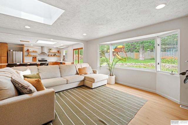 1133 S 96th St, Omaha, NE 68124 - living area with a skylight, light wood-style flooring, healthy amount of natural light, a textured ceiling, and recessed lighting