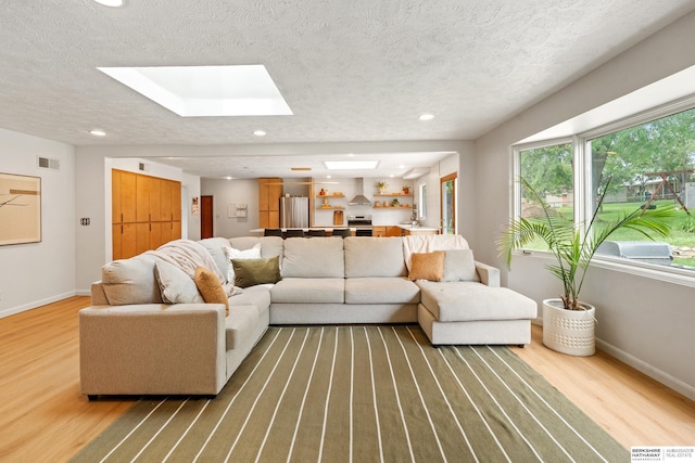 1133 S 96th St, Omaha, NE 68124 - living area with wood finished floors, a skylight, a textured ceiling, and recessed lighting