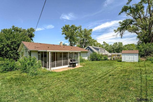 4509 Ridgeway Rd, Omaha, NE 68134 - rear view of house with a sunroom, a storage unit, a chimney, and a yard