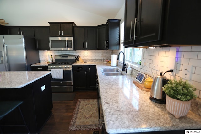 13719 S 43rd Ave, Bellevue, NE 68123 - kitchen featuring stainless steel appliances, dark cabinets, tasteful backsplash, vaulted ceiling, and light stone countertops