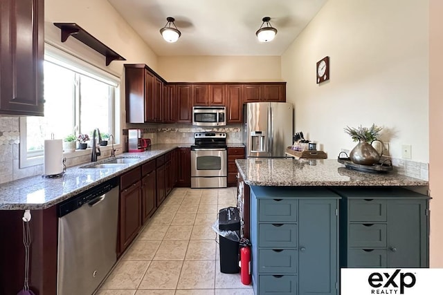 2611 N 189th St, Elkhorn, NE 68022 - kitchen featuring appliances with stainless steel finishes, backsplash, light tile patterned floors, light stone countertops, and a peninsula