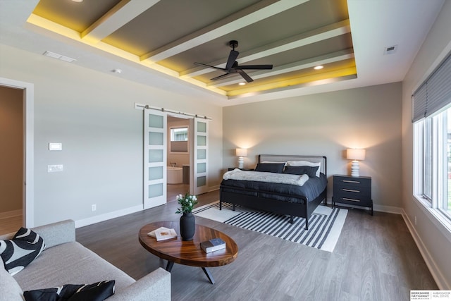 6217 N 295th St, Valley, NE 68064 - bedroom with a barn door, wood finished floors, beam ceiling, a ceiling fan, and ensuite bathroom
