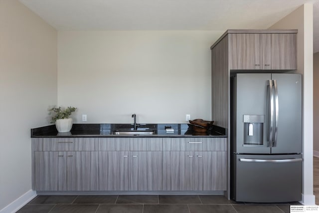 6217 N 295th St, Valley, NE 68064 - kitchen featuring stainless steel fridge, modern cabinets, dark stone counters, light brown cabinets, and dark tile patterned floors