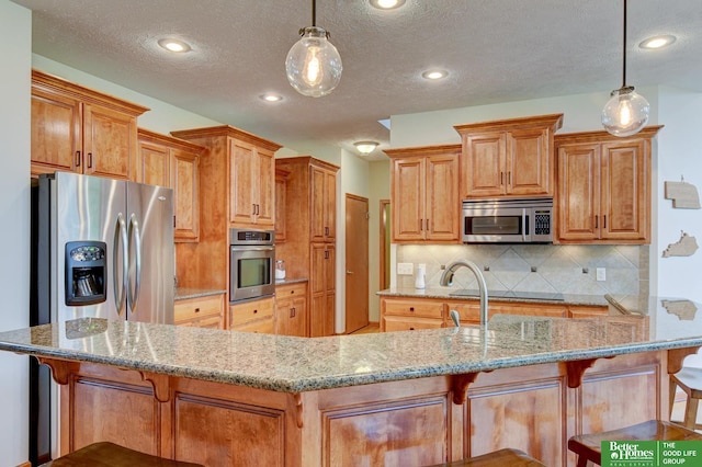 19311 Josephine St, Gretna, NE 68028 - kitchen featuring stainless steel appliances, backsplash, a breakfast bar area, light stone counters, and hanging light fixtures