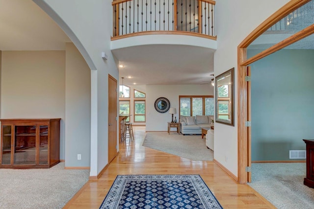 19311 Josephine St, Gretna, NE 68028 - foyer featuring arched walkways, wood finished floors, a ceiling fan, and a high ceiling
