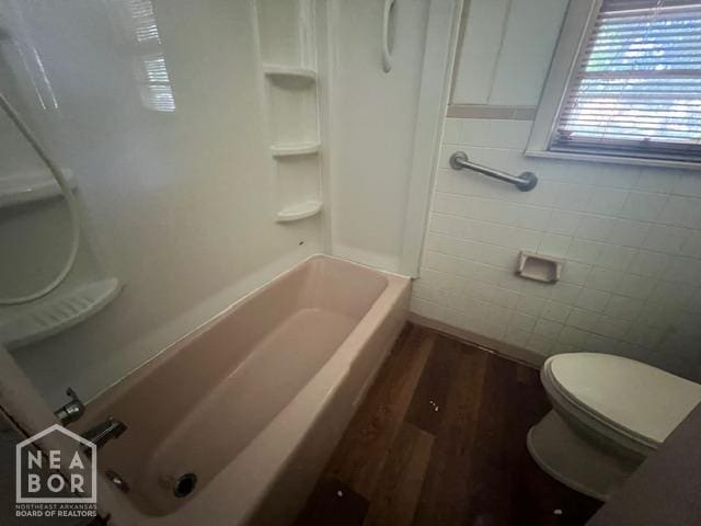 1508 N Easy St, Jonesboro, AR 72401 - bathroom with wood finished floors, tile walls, and shower / tub combination