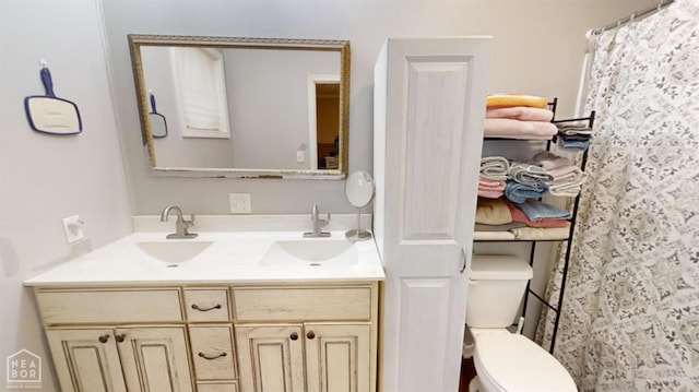 bathroom featuring a sink, toilet, double vanity, and a shower with shower curtain